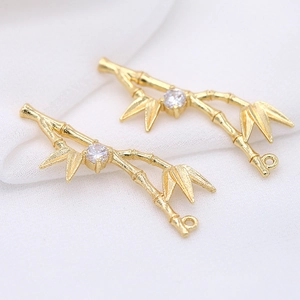 Macro detail of 14k gold bamboo style charms with sparkling round zircon stones