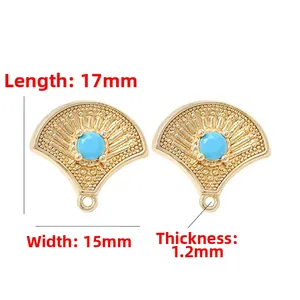 Detailed view of 14k gold fan-shaped jewelry pendant with blue zircon and beaded texture