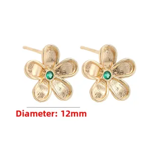 Detail of a 12mm 14k gold-plated flower earring with a green zircon stone and brushed finish