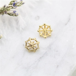 14K gold plated radial earring charms with zircons on marble background with dry flowers