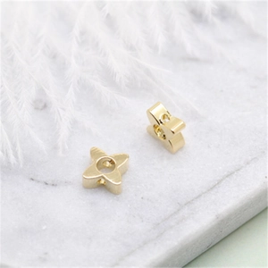 Macro shot of 14K gold plated star charms with cubic zirconia on marble background