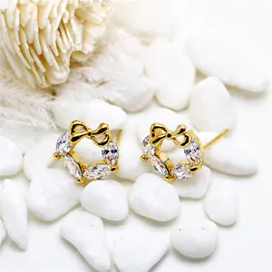 14K gold plated bow earrings with marquise zircon stones on white pebbles