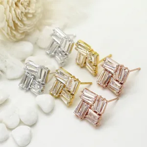 Close-up of square stud earrings with 14K gold plating and baguette zircon settings
