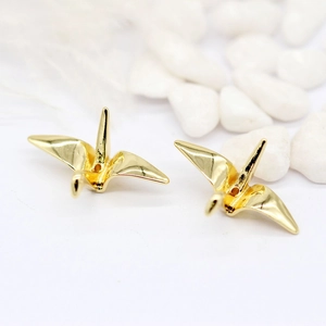Pendentif grue origami plaqué or 14K pour bijoux DIY sur lit de galets blancs