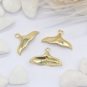 Drie elegante 14K gouden dolfijnenstaart hangers voor DIY sieraden op witte achtergrond