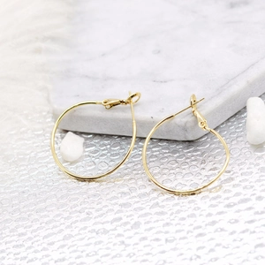 Créoles classiques en cuivre plaqué or 14K sur support marbre avec dentelle