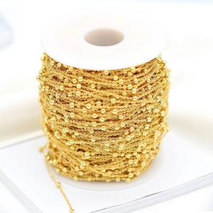 Détail de chaîne à billes plaquée or 14K pour bijoux sur bobine en plastique blanc