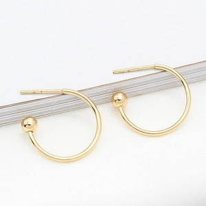 Pendientes minimalistas en forma de C bañados en oro de 14K con bola de metal sobre fondo blanco
