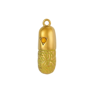 Detail of capsule pendant with orange gemstone and green textured maze pattern