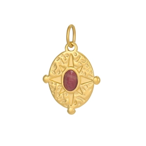 Macro view of vintage gold pendant with hammered texture and red oval gemstone inlay