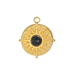 Macro detail of a vintage sunburst gold pendant with a black zircon gemstone inlay