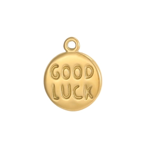 Macro shot of gold round stainless steel pendant engraved with GOOD LUCK text for DIY jewelry