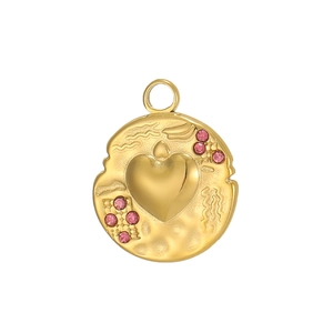Makroaufnahme eines Vintage-Herzanhängers in Gold mit rosa Kristallen und Hammerschlag-Optik