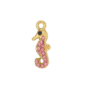 Macro shot of gold seahorse pendant with pink rhinestones and a black stone eye detail