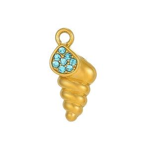 Macro shot of gold-plated seashell pendant with blue pavé zircons and matte finish