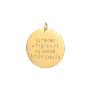 Macro detail of gold stainless steel round pendant with engraved teacher quote