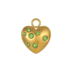 Détail d'un pendentif cœur doré avec six pierres vertes et une finition polie