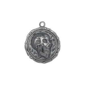 Close-up of vintage silver skull pendant with gothic relief and punk style metal hook