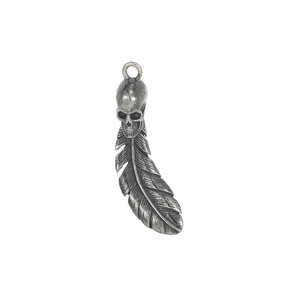 Macro detail of gothic skull and feather pendant in antique silver stainless steel