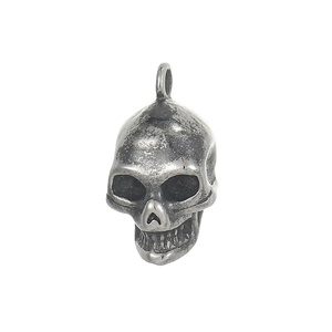Macro shot of gothic stainless steel skull pendant with oxidized vintage metal texture