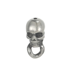 Macro view of vintage silver skull pendant showing detailed eye sockets and teeth
