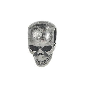 Macro detail of retro silver skull charm with vintage finish and side hole for DIY jewelry