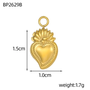 Detail of a 1.5cm golden heart pendant with engraved sunburst texture and metal loop
