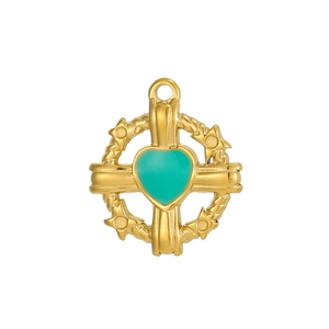Détail macro du pendentif croix dorée avec cœur turquoise et anneau métallique tissé