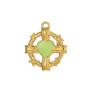 Détail macro du pendentif croix dorée avec cœur en émail vert et décorations d'étoiles