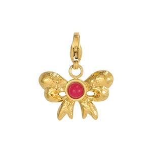 Detail of vintage golden bow pendant with red natural stone and hammered metal texture