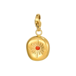 Detail of vintage sunburst tarot pendant in gold finish with red center gemstone