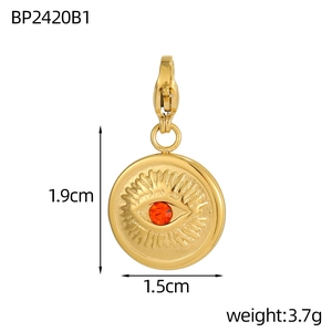 Macro detail of a golden evil eye pendant with a red ruby stone and size dimensions