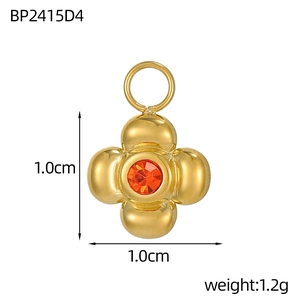 Dettaglio mini ciondolo a fiore in metallo dorato con zircone arancione e dimensioni