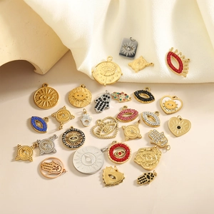 Baroque Hamsa Hand and Evil Eye pendants with colorful zircons on creamy fabric