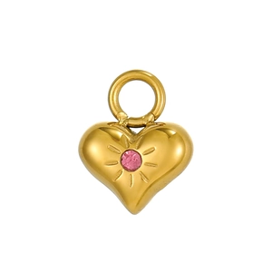 Dettaglio di un ciondolo a cuore dorato con pietra rosa e incisione a raggiera