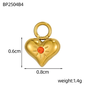 Dettaglio pendente cuore dorato con zircone arancione, dimensioni 0,8 cm per 0,6 cm