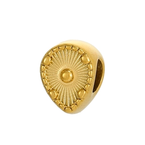 Détail macro du pendentif goutte dorée avec motif soleil et finition mate élégante