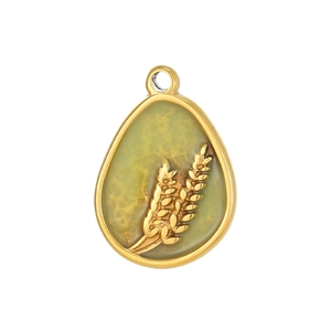 Detail view of pear shaped golden pendant with wheat relief and green inlay on white background