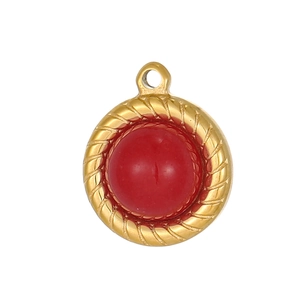 Macro shot of gold stainless steel round pendant featuring a deep red gemstone center