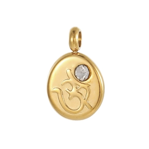 Macro detail of gold Om pendant with clear zircon inlay and polished metallic surface