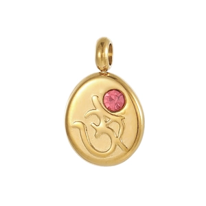 Macro shot of gold stainless steel Om pendant with an inlaid pink cubic zirconia stone