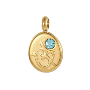 Detail of gold oval pendant with light blue stone and embossed Om religious symbol