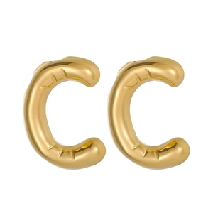 Macro view of gold plated C-letter puffy hoop earrings with textured metal surface