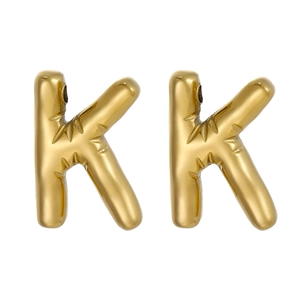 Detail of gold-plated stainless steel letter K pendant with radial textures and polished finish