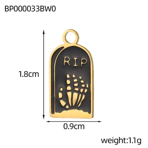 Macro shot of gold stainless steel gothic RIP pendant with black enamel skull hand detail
