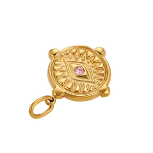 Macro detail of gold evil eye pendant featuring a pink zircon inlay and embossed relief