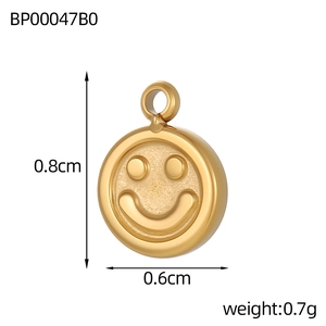 Detailed macro view of a vintage gold smiley face pendant with dimensions 0.8cm and 0.6cm
