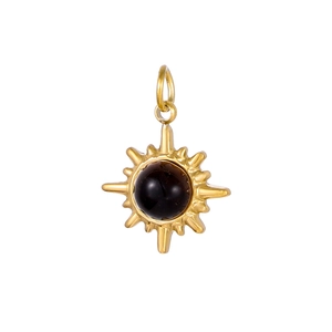 Detailed view of vintage gold sunburst pendant with a black stone inlay and hanging loop