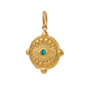 Detailed macro view of vintage gold evil eye pendant with blue zircon inlay on white backdrop