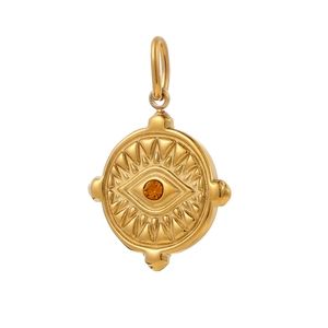 Macro detail of golden sun-eye pendant with orange zircon and radial carvings